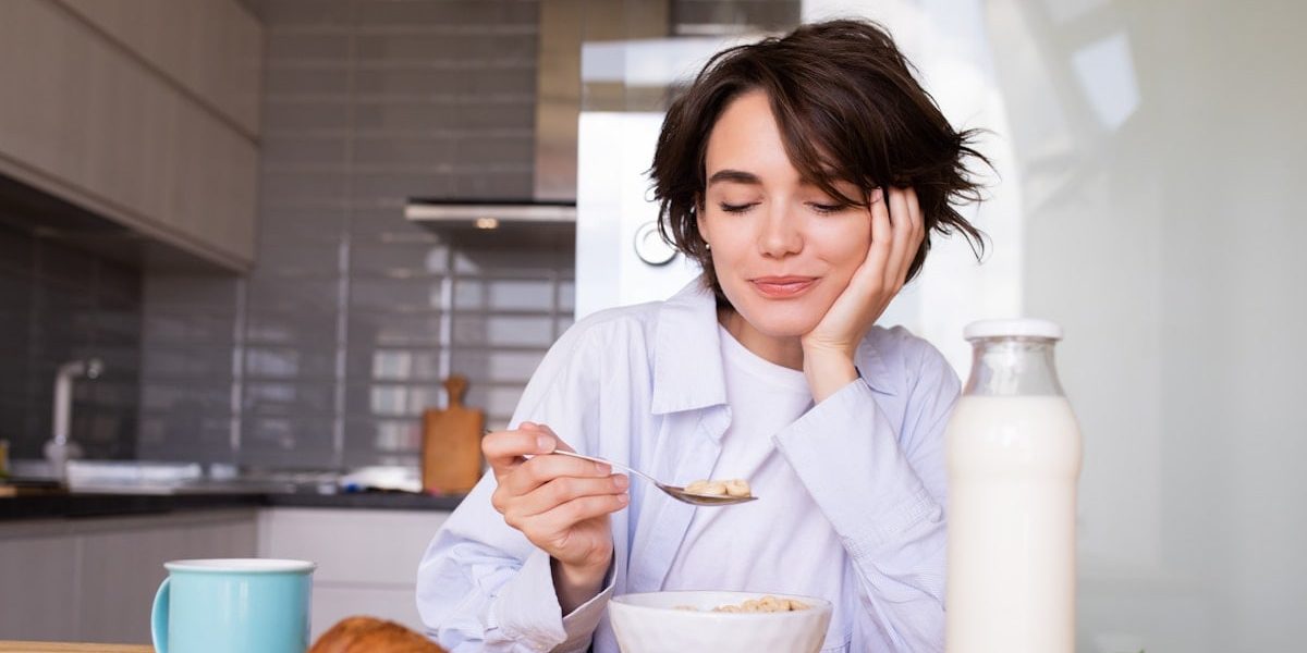 a woman sitting at a table with a plate of food
