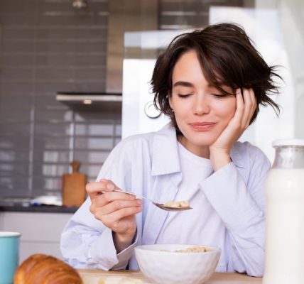 a woman sitting at a table with a plate of food