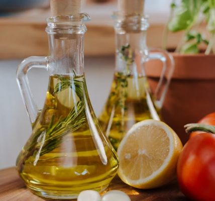 Close-up of fresh ingredients for Italian cooking featuring olive oil and basil.