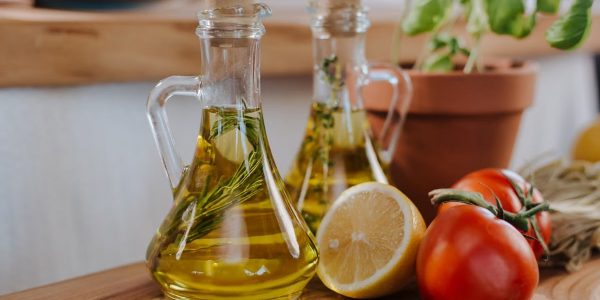 Close-up of fresh ingredients for Italian cooking featuring olive oil and basil.