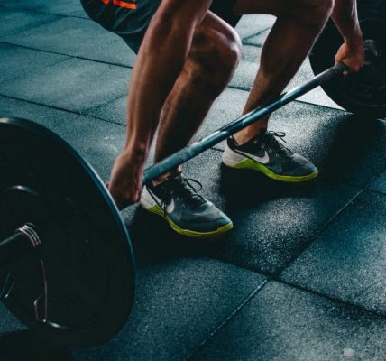 Man performing a deadlift exercise in a gym, demonstrating strength and fitness.