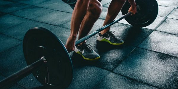 Man performing a deadlift exercise in a gym, demonstrating strength and fitness.